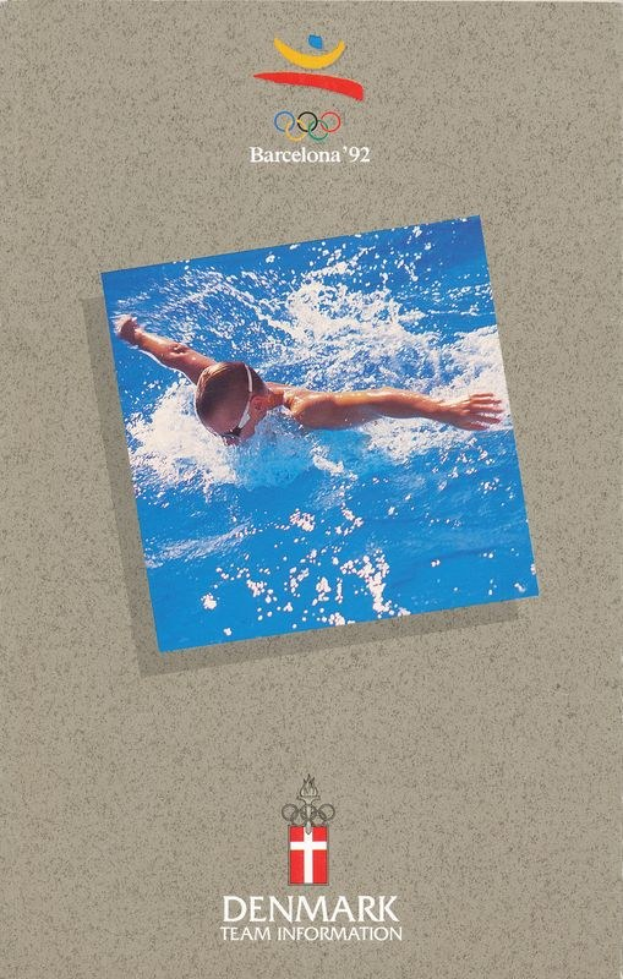 Plakat für die Olympischen Spiele 1992 in Barcelona, das einen Schwimmer in einem blauen Anzug mit ausgestreckten Armen zeigt, vor einem hellblauen Himmel mit weißen Wolken, mit dem offiziellen Logo und der Aufschrift "Danish Team Information".