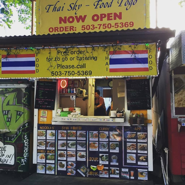 Läden, Getränkedosen, Speisekarten, eine Uhr, Gewürze in Plastikbehältern, Kondimente, Werbetafeln, Namensschilder und der Himmel.