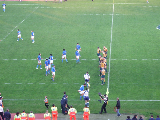 Eine Gruppe von Menschen auf einem Fußballfeld, eine Person hält eine Videokamera.