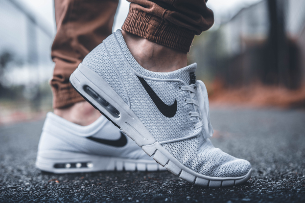 Nahaufnahme von Nike SB Stefan Janoski Max Schuhen in Wolf Grau/Schwarz-Weiß auf einem unscharfen Hintergrund.
