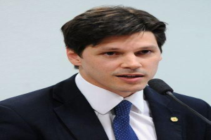 Ein Mann im Anzug und Krawatte spricht in ein Mikrofon und scheint eine Äußerung im Zusammenhang mit der Genehmigung eines Gesetzes durch die Regierung zu machen, das den Internetgebrauch verbietet.