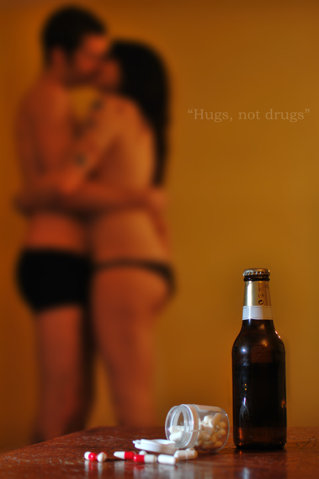 Eine Wand mit zwei Personen, die in der Nähe eines Tisches stehen, auf dem sich eine Flasche, eine Schachtel und einige Tabletten befinden.