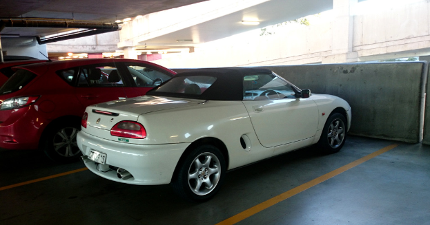  Autos in einem Keller mit einem Rohr am Dach und einem weiteren Gebäude auf der rechten Seite oben.