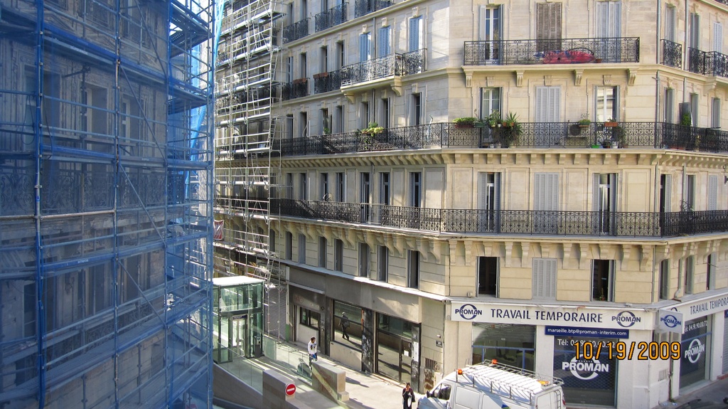 Ein großes Gebäude auf der linken Seite, mit einem Geschäft auf der unteren rechten Seite.