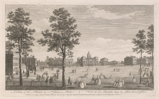 Eine Gruppe von Menschen, die während eines Umzugs in St. James Park stehen und sitzen, mit Bäumen und Gebäuden im Hintergrund unter einem bewölkten Himmel.