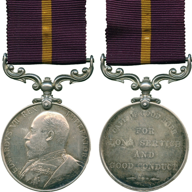 Silberne Medaille mit lila und gelben Band, mit einem Profilbild auf der linken Seite und dem Text "Langjähriger Dienst und gutes Benehmen" auf der rechten Seite.