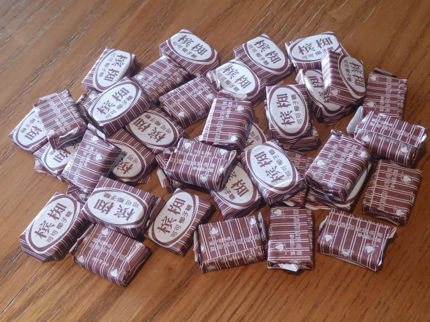 Stapel Schokoladen mit Text auf einem hölzernen Tisch.