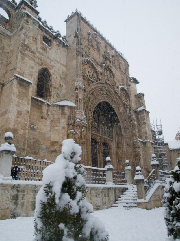 Eine architektonische Struktur mit schneebedeckter Erde und eisbedeckten Bäumen im Vordergrund.