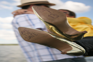 Frauenabsätze mit Datumsangaben darauf, mit einer Person, die eine Frau von hinten hält.