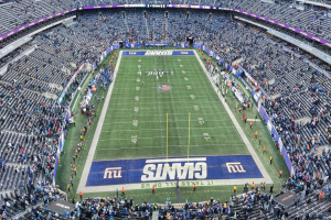 Ein Fußballstadion voller Zuschauer, Spieler, Pfosten und Schilder mit Text, alle auf Stühlen sitzend, die eine lebendige Atmosphäre schaffen.