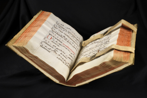 Offenes Buch mit Noten und Text auf schwarzem Hintergrund, identifiziert als Bibl Mazarine.