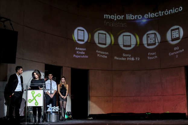 Vier Personen auf der linken Seite, wobei eine Frau einen Vortrag hält, und im Hintergrund Bilder von Geräten mit ihren Namen darunter.