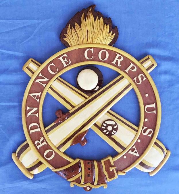 Holzschild mit 'Ordnance Corps'-Text, verziert mit einem geschnitzten weißen Stern auf einem navyblauen Hintergrund mit goldener Umrandung, auf blauem Tuch montiert.