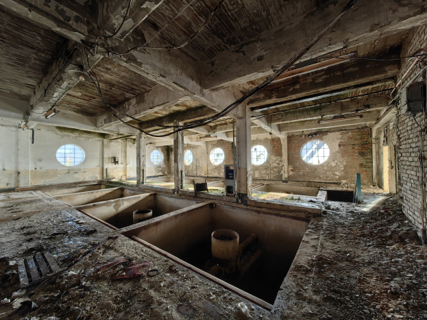 Verlassenes Gebäude im Innern der Sperrzone von Tschernobyl mit verstreuten Trümmern, freiliegenden Wänden, Decke und Bauelementen.