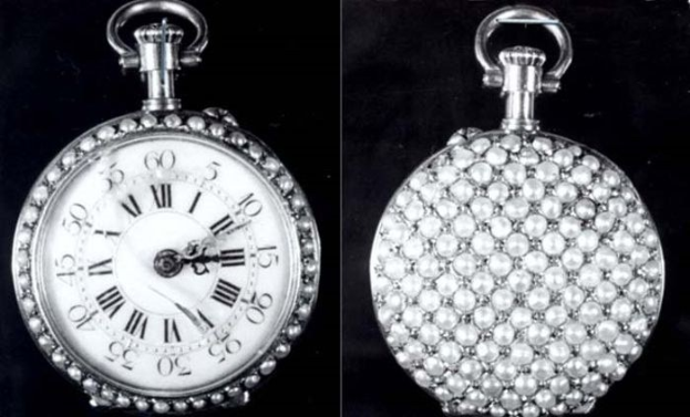 Eine silberne Taschenuhr mit Diamanten, die in einem runden Zifferblatt mit römischen Zahlen eingelassen sind, auf einem schwarzen Hintergrund.