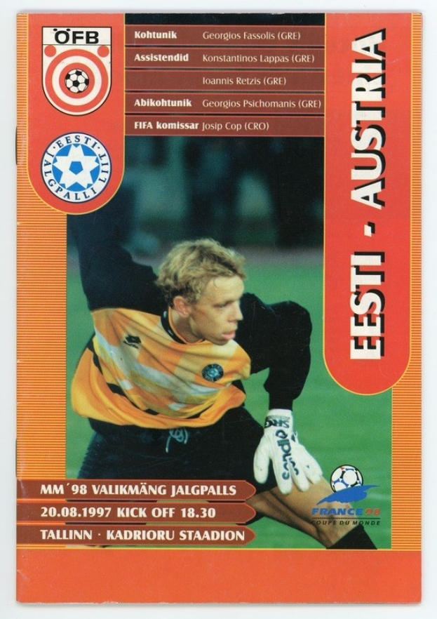 Fußballkarte aus der FIFA WM 1998 mit einem Spieler in einem Jersey mit entschlossener Miene, vor einem hellblauen Himmel mit weißen Wolken.
