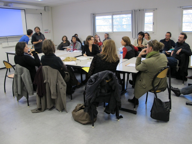 Eine Gruppe von Menschen, die sich unterhält, mit zwei Personen im Hintergrund, die sich unterhalten.