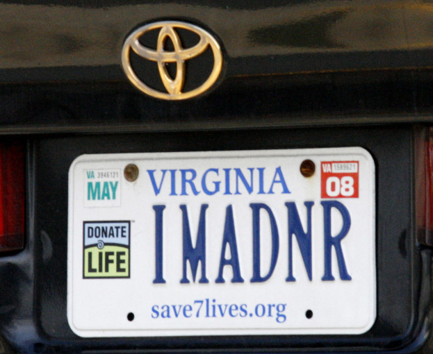 Ein Fahrzeuglogo und eine Typenschilder mit Zahlen und Wörtern am Fahrzeug.