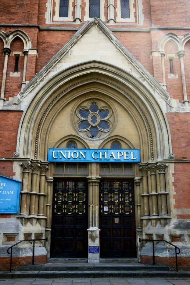 Eine große Kirche in London mit vielen Fenstern und zwei Türen am Eingang.