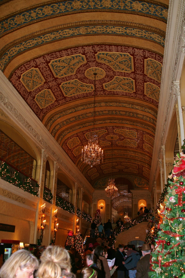 Eine Gruppe von Menschen, die zwischen Pflanzen mit Lampen und Lampen an der Decke steht.