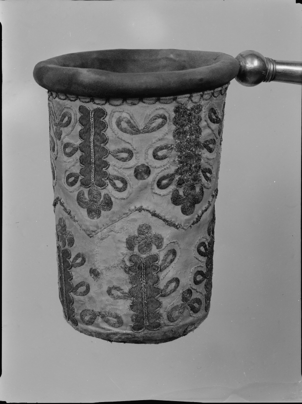 Ein Schwarz-Weiß-Foto eines Stoff-Abfallpapierkorbs mit Griff.