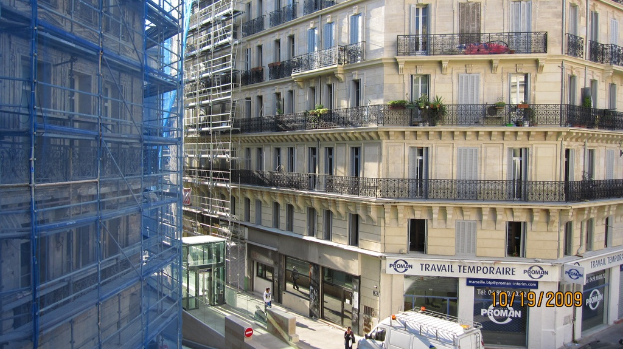 Ein großes Gebäude in Bau auf der linken Seite, mit einem Geschäft auf der unteren rechten Seite.