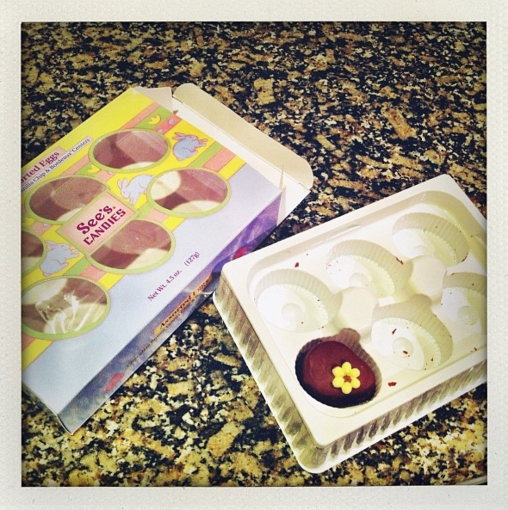 Ein Karton mit Tierbildern und Text neben einem Tablett mit Essen, das auf einem steinernen Sockel steht.