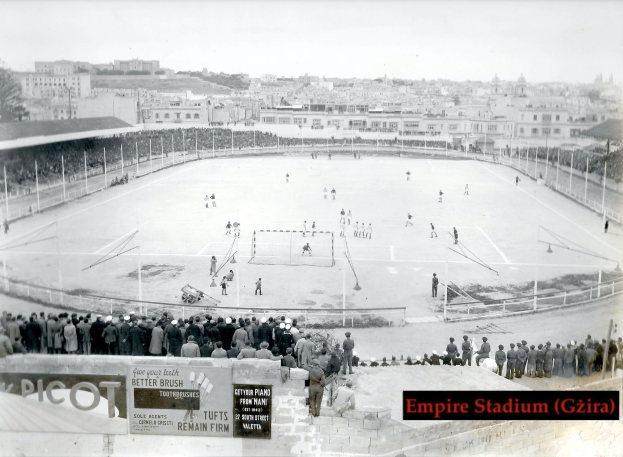 Ein Schwarz-Weiß-Foto des Empire Stadiums in Giza mit einer Gruppe von Menschen, die in der Mitte Eishockey spielen, umgeben von einem Zaun, mit Gebäuden und Bäumen im Hintergrund und Text unten.
