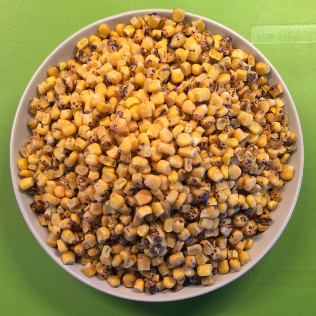 Ein weißer Napf voller Maiskörner wird gegen einen grünen Hintergrund mit Text unten platziert.