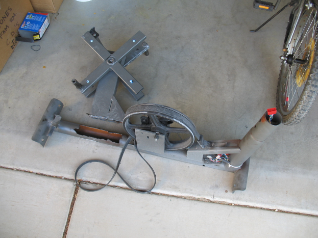 Eine Maschine auf dem Boden mit einem Teil eines Fahrrads im oberen rechten Eck.