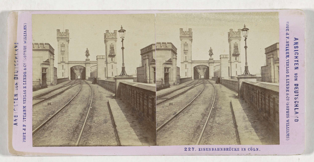 Schwarz-weißes stereoskopisches Bild einer Zugstrecke mit der Eisenbahnbrücke in Köln, Deutschland, das Schienen, Wände, Pfosten, Statuen, Himmel und Text zeigt.