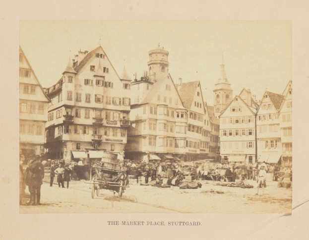 Schwarz-weißes Foto eines belebten Marktplatzes in Stuttgart, Deutschland, mit Gebäuden mit Fenstern, Menschen, Karren und diversen Gegenständen sowie Text unten.
