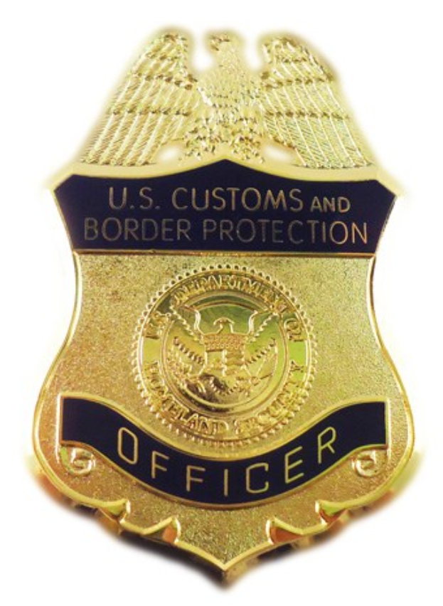 Goldenes Abzeichen mit der Aufschrift "U.S. Customs and Border Protection Officer" auf weißem Hintergrund.